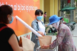 Người dân đến nhận gạo miễn phí tại cây ATM gạo. (Ảnh: Trần Việt/TTXVN)