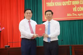Trưởng Ban Tuyên giáo Trung ương Nguyễn Trọng Nghĩa (trái) trao Quyết định cho đồng chí Trần Thanh Lâm. (Ảnh: Chương Đài/TTXVN)