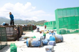 Người dân thôn Bình Lập, xã Cam Lập, cho rằng ô nhiễm tại khu vực này xuất phát từ quá trình vệ sinh các lồng bè nuôi thủy sản. (Ảnh: Đặng Tuấn/TTXVN)