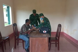 Bộ đội biên phòng tỉnh Đắk Lắk thăm khám ban đầu cho bệnh nhân. (Ảnh: TTXVN phát)