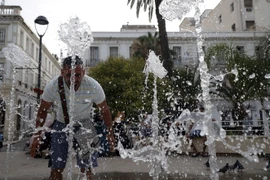 Người dân giải nhiệt tại một đài phun nước ở Algiers, Algeria ngày 10/7 vừa qua. (Ảnh: THX/TTXVN)