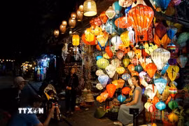 Du khách quốc tế chụp ảnh tại Phố cổ Hội An. (Nguồn: TTXVN)
