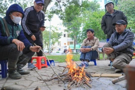 Dù ban ngày có nắng, nhưng nền nhiệt giảm sâu khiến nhiều người dân phải đốt lửa sưởi ấm. (Ảnh: Hoàng Hiếu/TTXVN)