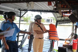 Lực lượng chức năng kiểm tra điều kiện hoạt động của phương tiện đò ngang hoạt động trên kênh xáng Xà No, tỉnh Hậu Giang. (Ảnh: Nguyễn Hằng/TTXVN)