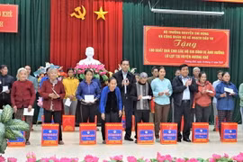 Bộ trưởng Bộ Kế hoạch và Đầu tư Nguyễn Chí Dũng và lãnh đạo UBND tỉnh tặng quà cho các hộ dân bị ảnh hưởng lũ lụt tại huyện Hương Khê. (Ảnh: Hữu Quyết/TTXVN)