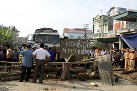 Người dân tự ý chắn đường, xếp đá, đặt hình nộm trên Quốc lộ 4E tại xã Gia Phú, huyện Bảo Thắng. (Ảnh: baolaocai.vn)