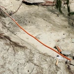 Xói lở cát làm lộ thiên ống điện ngầm. (Ảnh: Lê Phước Ngọc/TTXVN)