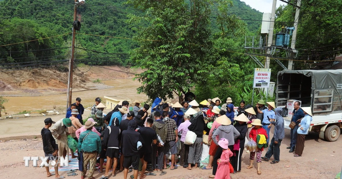 Người dân các bản còn cô lập nhận lương thực, thực phẩm, nhu yếu phẩm từ các hoạt động thiện nguyện tại bản Xiềng Tắm (xã Mỹ Lý, tỉnh Nghệ An) trước khi đưa xuống thuyền để chở về bản làng. (Ảnh: Xuân Tiến/TTXVN)