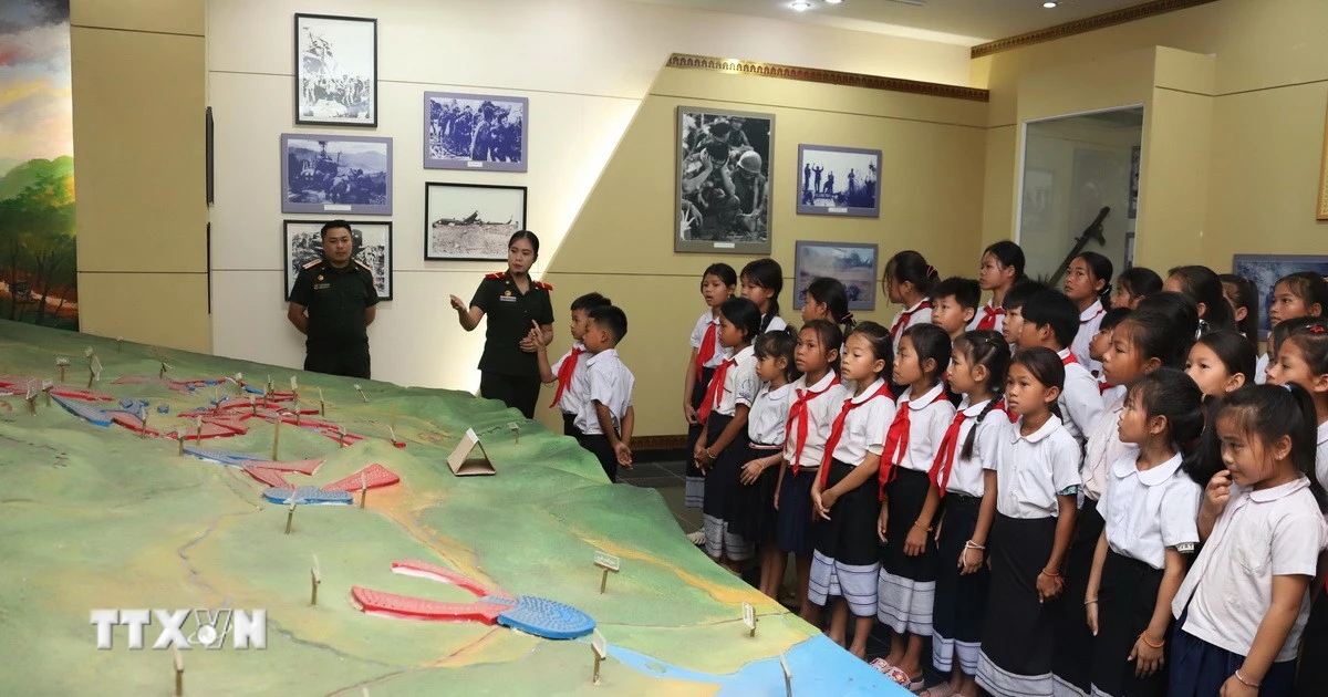 Học sinh trường Dongsavanh, huyện Sepon (Savannakhet, Lào) tham quan sa bàn ghi lại các trận đánh ác liệt của Liên minh chiến đấu Việt Nam-Lào. (Ảnh: TTXVN)