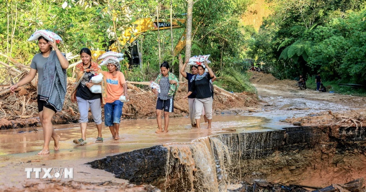 Người dân tại khu vực bị ảnh hưởng nặng nề bởi lũ lụt ở Bắc Sumatra, Indonesia nhận nhu yếu phẩm cứu trợ, ngày 2/12/2025. (Ảnh: THX/TTXVN)