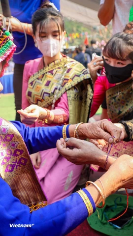 Tục buộc chỉ cổ tay cầu mong may mắn trong Lễ hội té nước hay còn gọi là Bun huột nặm của người Lào ở Điện Biên để chào đón năm mới. (Ảnh: Hoài Nam/Vietnam+)