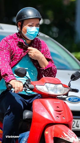 Người dân di chuyển dưới trời nắng gắt. (Ảnh: Hoài Nam/Vietnam+)