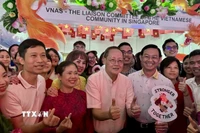Bộ trưởng Bộ Nhân lực Singapore Tan See Leng (áo trắng, giữa) tại gian hàng của cộng đồng người Việt Nam. (Ảnh: Đỗ Vân/TTXVN)