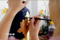Vẽ hoa văn trên sản phẩm gốm sứ tại làng nghề Hạ Thái. (Ảnh: Trần Việt/TTXVN)