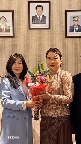 Đại sứ Đỗ Hùng Việt và Phu nhân chúc mừng Đại sứ Lào Thongphane Savanphet và Phu nhân. (Ảnh: Thanh Tuấn/TTXVN)