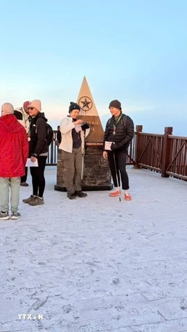 Du khách thích thú khi được trải nghiệm băng giá trên đỉnh Fansipan. (Ảnh: TTXVN phát)