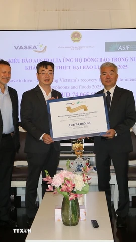 Giáo sư Nghiêm Đức Long (thứ hai, trái sang), Chủ tịch VASEA trao tượng trưng số tiền quyên góp ủng hộ đồng bào vùng bão lũ cho đại diện Tổng Lãnh sự Việt Nam tại Sydney Nguyễn Thanh Tùng. (Ảnh: Thanh Tú/TTXVN)