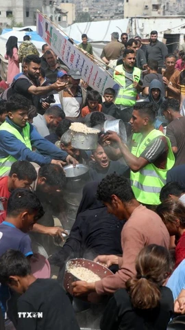 Người dân Palestine nhận thức ăn cứu trợ tại thành phố Gaza ngày 2/5/2025. (Ảnh: THX/TTXVN)