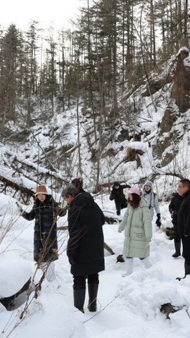 Du khách thích thú chụp ảnh dưới chân Trường Bạch Sơn. (Ảnh: Quang Hưng/TTXVN)