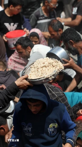 Người dân nhận thực phẩm cứu trợ tại Gaza. (Ảnh: THX/TTXVN)