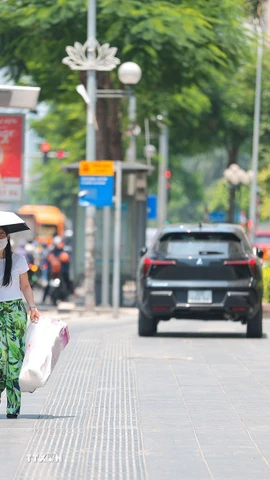 Người dân vất vả khi phải di chuyển giữa trời nắng gay gắt. (Ảnh: Lê Đông/TTXVN)