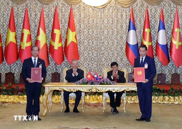 https://media.vietnamplus.vn/images/c34db8af82f87991fa732baa4c9e0f73f4965c78cf40473bbefc512cfe35dd3ee8c515e4b3e7668b69c91a140c7b3899db2794e1e7fc4f7001109875410040cfdf46926edf593d68b85014039170aef5da0ec4b8f36dc19ebf89aa76172939a6038a2db2e15b4797daacfc467355fe251441bc32f974f5844520b8cb17925ff906f3a3158c5bebf98b6f4feb76a73c2f/ttxvn-tong-bi-thu-to-lam-va-tong-bi-thu-chu-tich-nuoc-lao-chung-kien-le-trao-cac-van-kien-hop-tac-3.jpg.webp