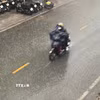Người dân di chuyển trong mưa rào. (Ảnh: Hồng Đạt /TTXVN)