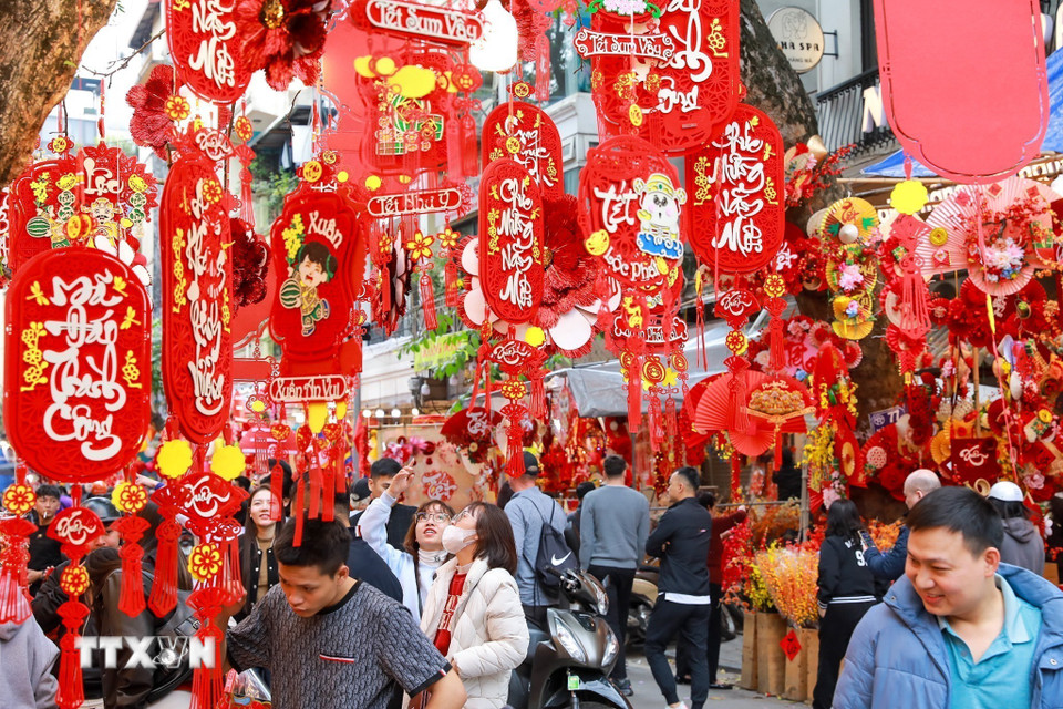 Không khí mua sắm nhộn nhịp cùng những sắc màu rực rỡ của mùa Xuân giữa lòng phố cổ tạo nên sức hấp dẫn cho chợ hoa Hàng Lược. (Ảnh: Khánh Hòa/TTXVN)