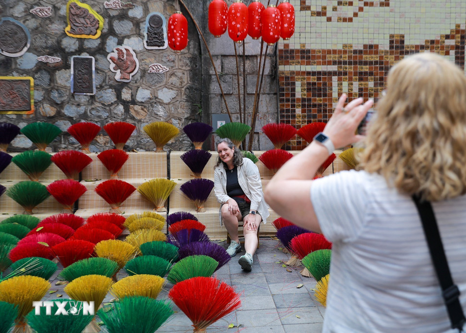 Du khách lưu lại không khí Tết tại không gian phố bích họa. (Ảnh: Khánh Hòa/TTXVN)