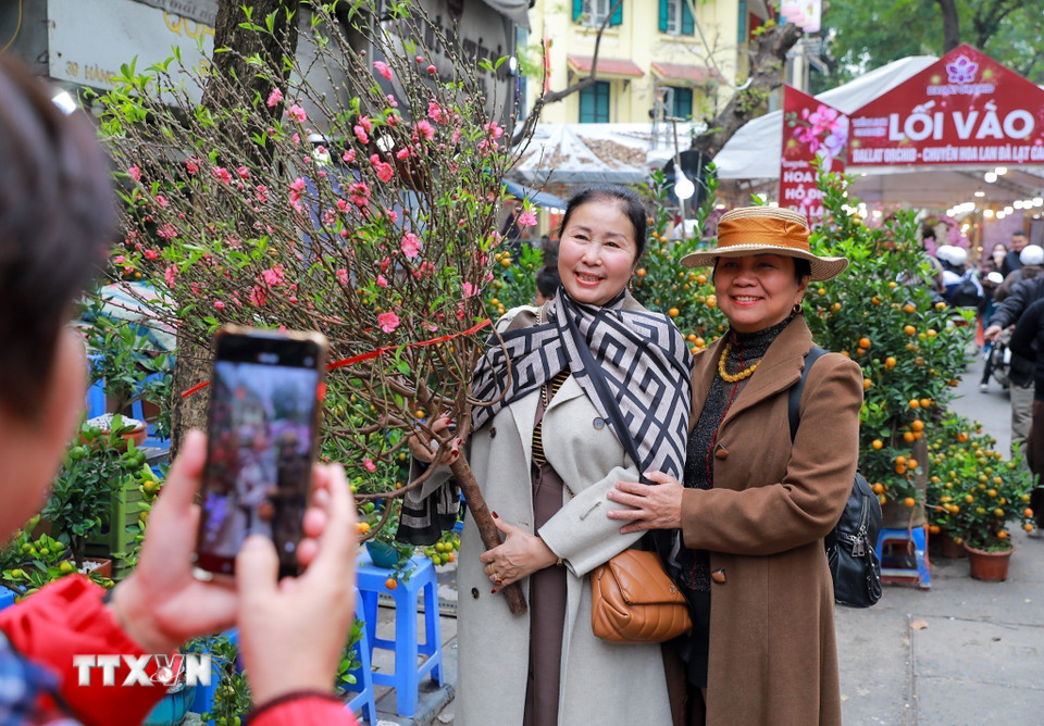 Người dân lưu lại không khí Tết tại chợ hoa Hàng Lược. (Ảnh: Khánh Hòa/TTXVN)