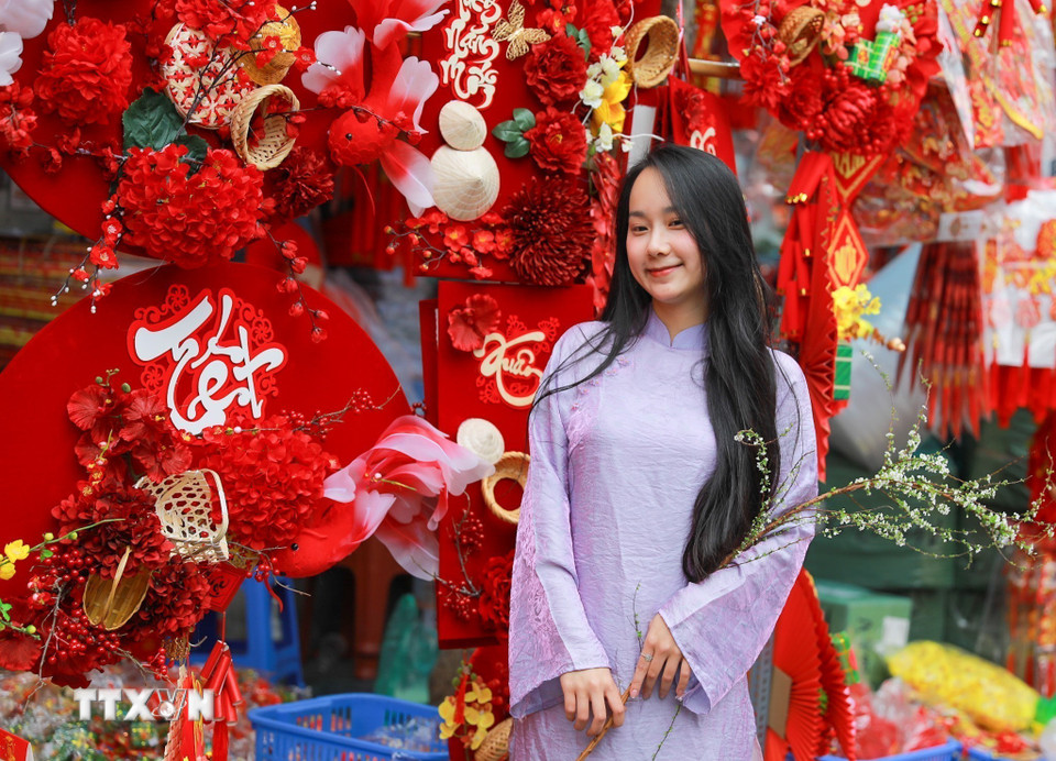 Người dân lưu lại khoảnh khắc tại chợ hoa Hàng Lược. (Ảnh: Khánh Hòa/TTXVN)