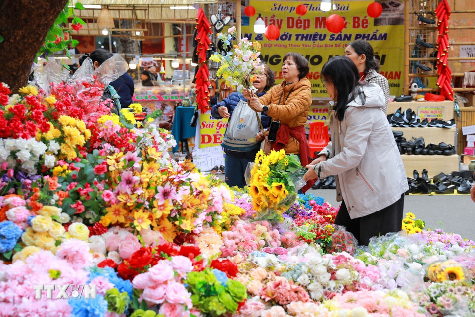 Tới chợ hoa Hàng Lược người ta không chỉ đi mua sắm những mặt hàng thiết yếu mà còn tận hưởng không khí Tết cận kề. (Ảnh: Khánh Hòa/TTXVN)