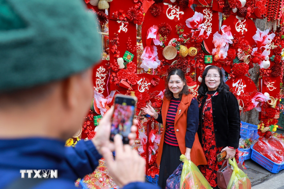 Người dân lưu lại không khí Tết tại chợ hoa Hàng Lược. (Ảnh: Khánh Hòa/TTXVN)