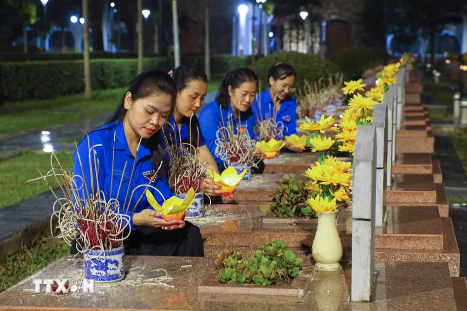 Đoàn viên thanh niên thắp đèn hoa sen, dâng hương tại phần mộ các Anh hùng liệt sỹ ở Nghĩa trang Liệt sỹ quốc gia A1 (Điện Biên). (Ảnh: Xuân Tư/TTXVN)
