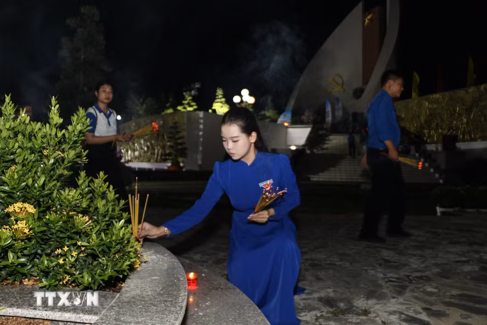 Đoàn viên thắp hương lên phần mộ liệt sỹ. (Ảnh: Hồng Thái/TTXVN)