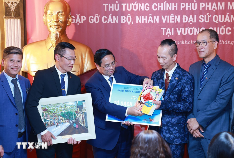 Thủ tướng Phạm Minh Chính tặng quà cho đại diện cộng đồng người Việt Nam tại Thụy Điển. (Ảnh: Dương Giang/TTXVN)