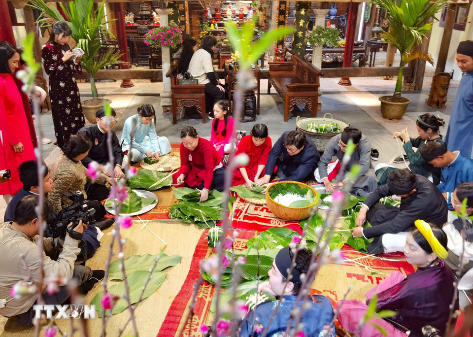 Giữa lòng phố cổ, cùng gói bánh chưng đón Tết như cách của người Hà Nội xưa. (Ảnh: Thanh Tùng/TTXVN)