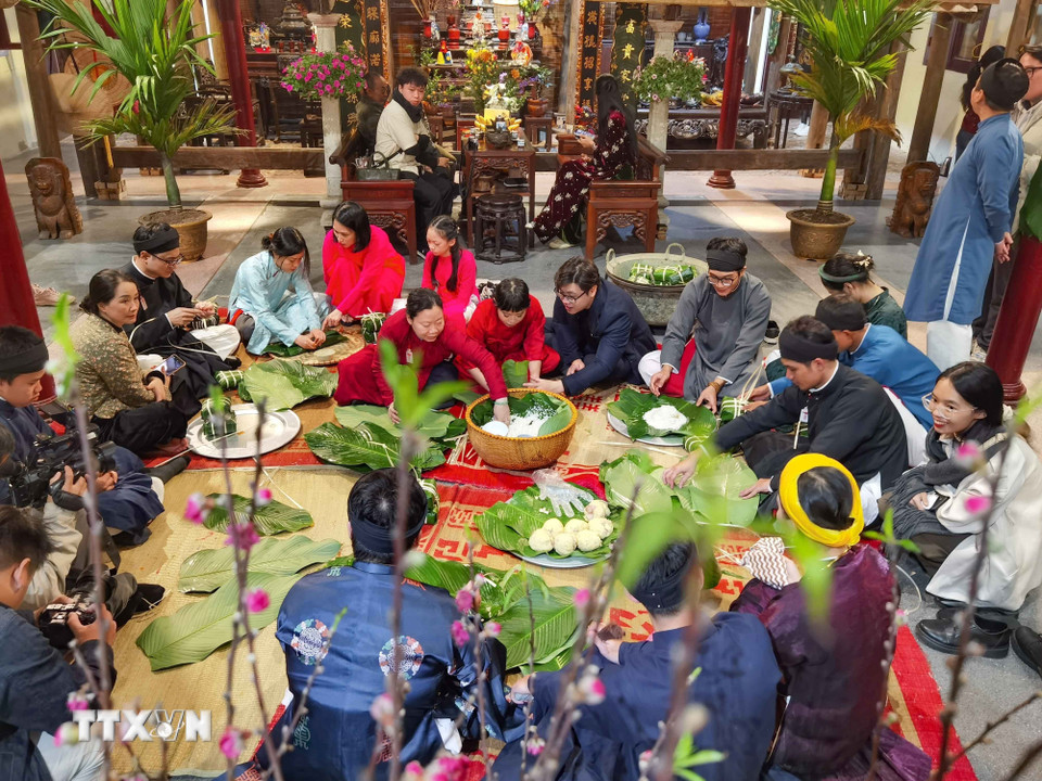 Giữa lòng phố cổ, cùng gói bánh chưng đón Tết như cách của người Hà Nội xưa. (Ảnh: Thanh Tùng/TTXVN)