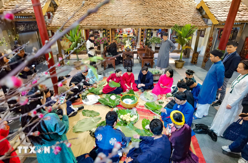 Giữa lòng phố cổ, cùng gói bánh chưng đón Tết như cách của người Hà Nội xưa. (Ảnh: Thanh Tùng/TTXVN)