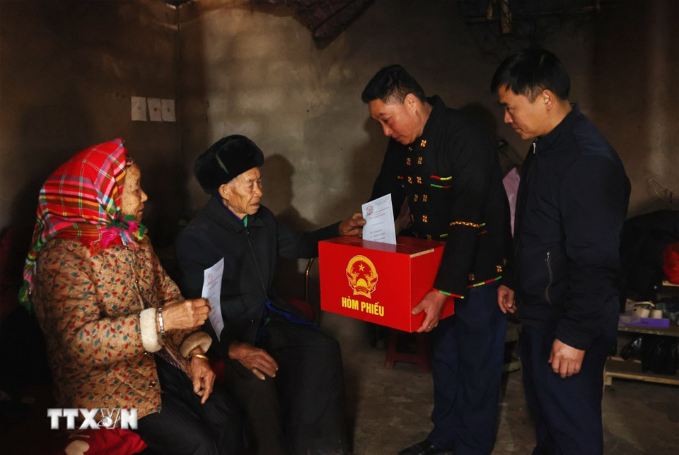 Tổ công tác mang hòm phiếu di động đến nhà cho cử tri là người già và người khuyết tật thực hiện quyền bầu cử. (Ảnh: Minh Đức/TTXVN)