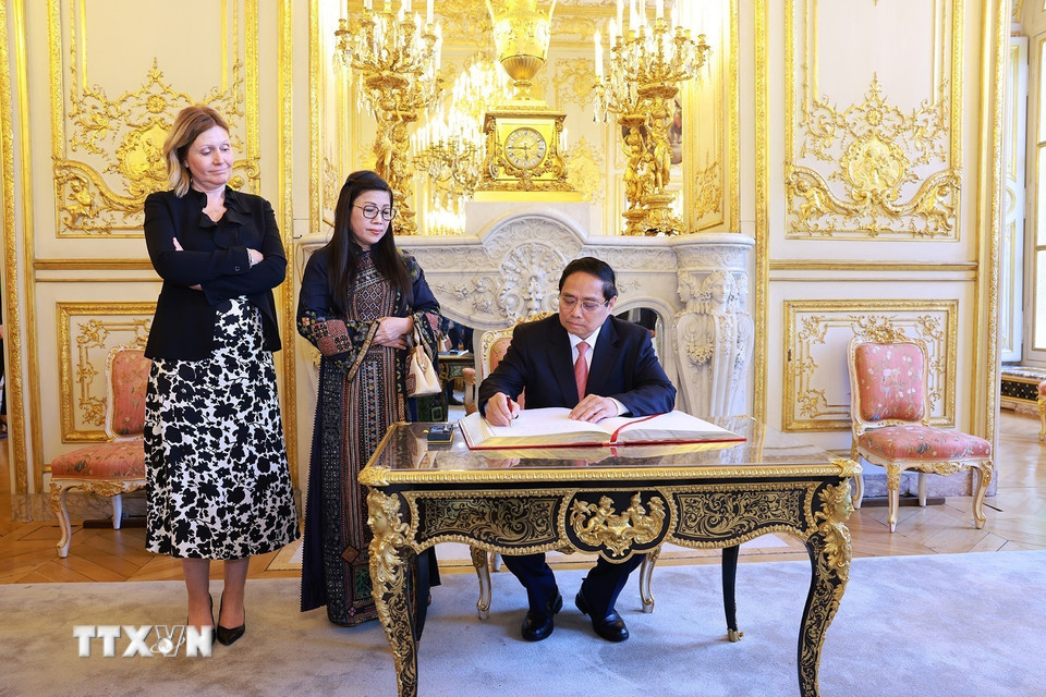 Thủ tướng Phạm Minh Chính viết sổ lưu bút. (Ảnh: Dương Giang/TTXVN)