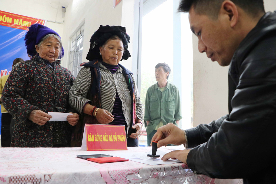 Đóng dấu hoàn thành bỏ phiếu cho cử tri tại tổ bầu cử số 4 bản Tung Qua Lìn, xã Dào San. (Ảnh: Nguyễn Oanh/TTXVN)