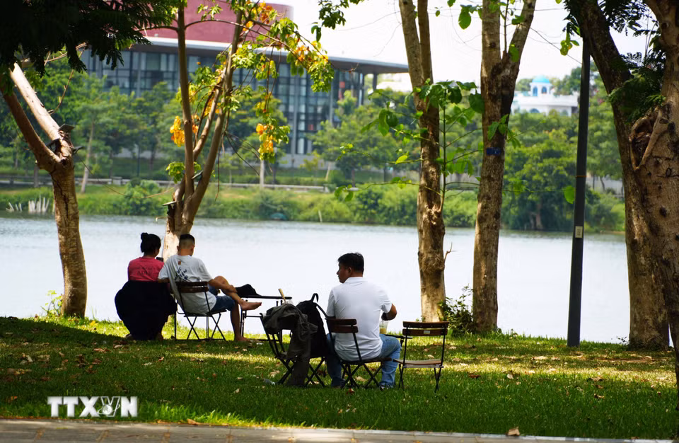 Người dân đến công viên bờ Bắc sông Hương, thành phố Huế để hóng mát, tránh nắng nóng gay gắt. (Ảnh: Nguyên Lý/TTXVN)