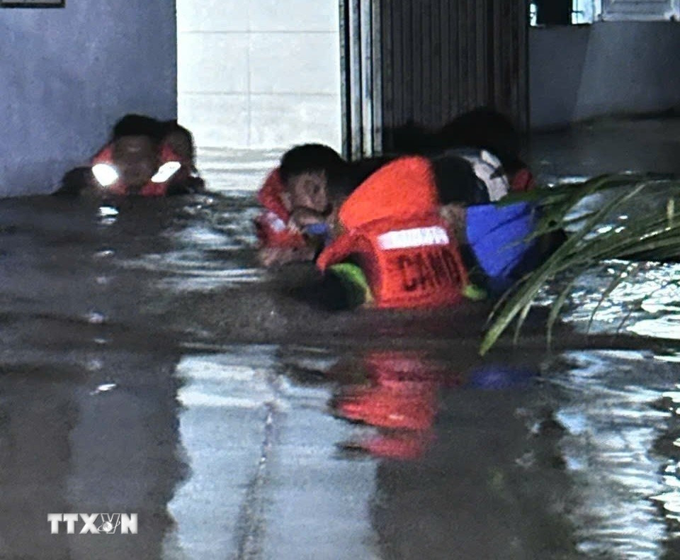 Giải cứu an toàn hơn 160 người mắc kẹt trong mưa lớn, ngập sâu tại phường Bến Cát. (Ảnh: TTXVN phát)