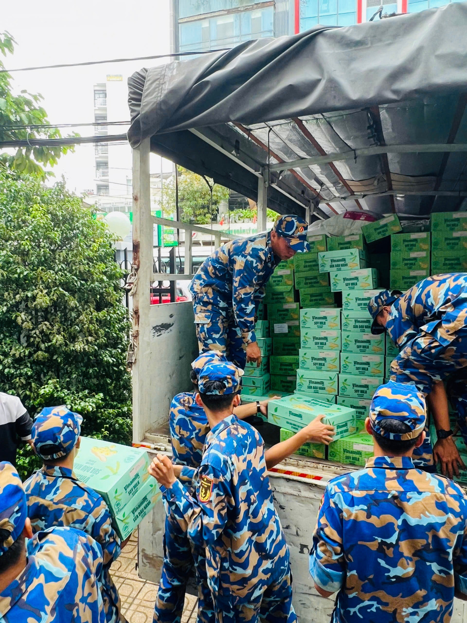 Các chiến sỹ Trung tâm Huấn luyện Vùng 4 Hải quân đang chuyền nhau các sản phẩm dinh dưỡng Vinamilk, sẵn sàng vận chuyển đến tận tay bà con vùng lũ. (Ảnh: Vi Nam)