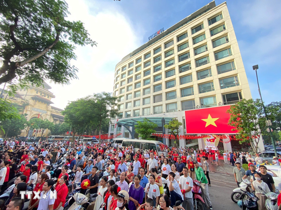 Người dân tập trung trước cổng TTXVN theo dõi truyền hình trực tiếp Lễ diễu binh, diễu hành kỷ niệm 80 năm Quốc khánh. (Ảnh: Nhật Anh/TTXVN)