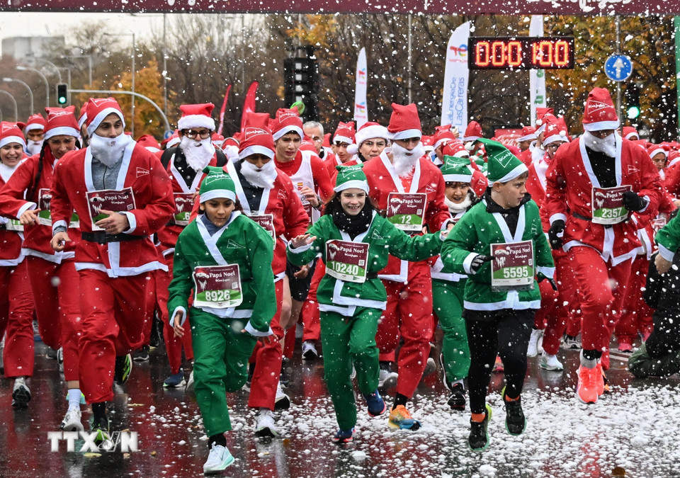 Người dân tham gia cuộc thi chạy Ông già Noel tại Madrid, Tây Ban Nha. (Ảnh: THX/TTXVN)