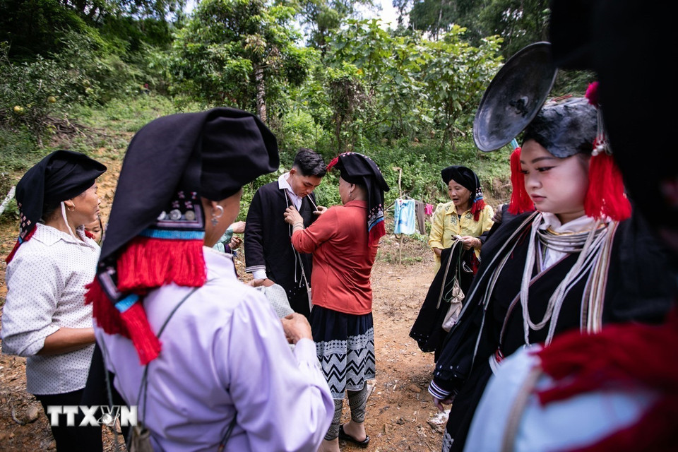 Chú rể và cô dâu sau khi kết thúc các nghi thức cưới tại rạp sẽ mặc lại trang phục truyền thống của người Dao Tiền rồi mới được dẫn vào gian thờ chính, nơi thầy cúng làm lễ báo cáo với tổ tiên (Ảnh: Trọng Đạt/TTXVN)