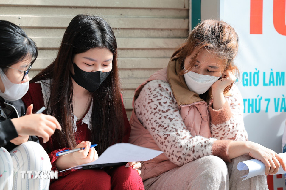 Người dân làm báo cáo thiệt hại tài sản sau vụ cháy chợ Xanh Định Công. (Ảnh: Lê Đông/TTXVN)