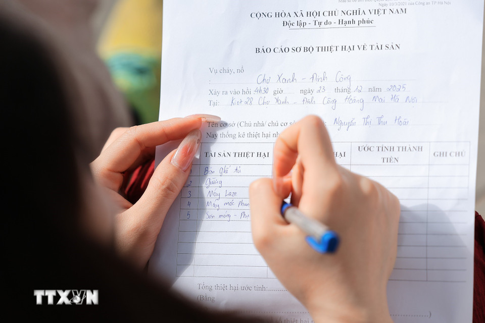 Người dân làm báo cáo thiệt hại tài sản sau vụ cháy chợ Xanh Định Công. (Ảnh: Lê Đông/TTXVN)